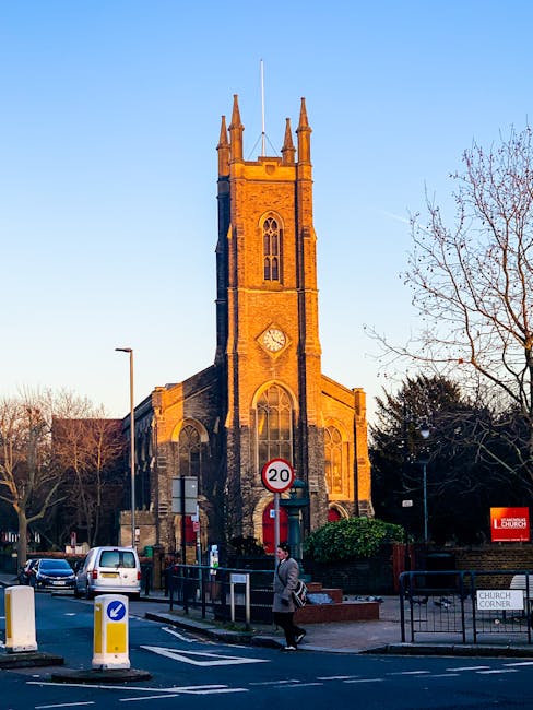 A street scene in Selsdon featuring a red double-decker bus traveling along the road in front of a multi-storey residential building with brick and white paneling details. The building has several whi